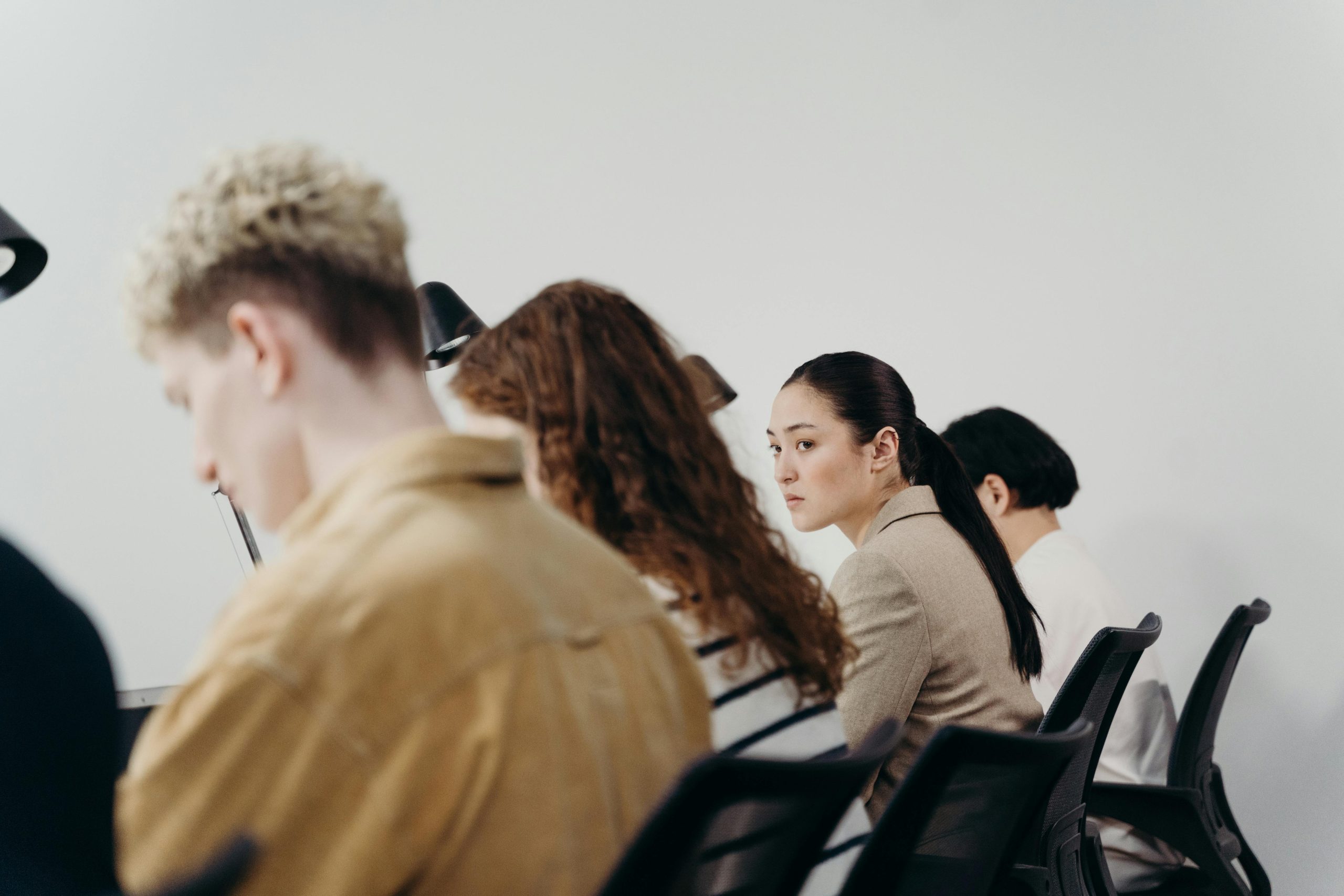 a team of people sat in a row. one person looks over at another.